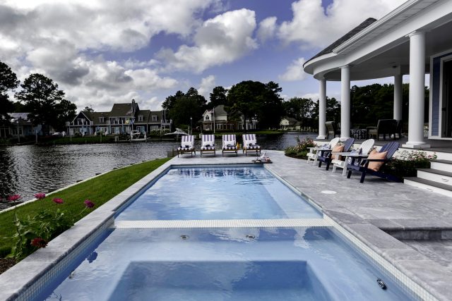 Traditional swimming pool by lake - Master Pools Guild